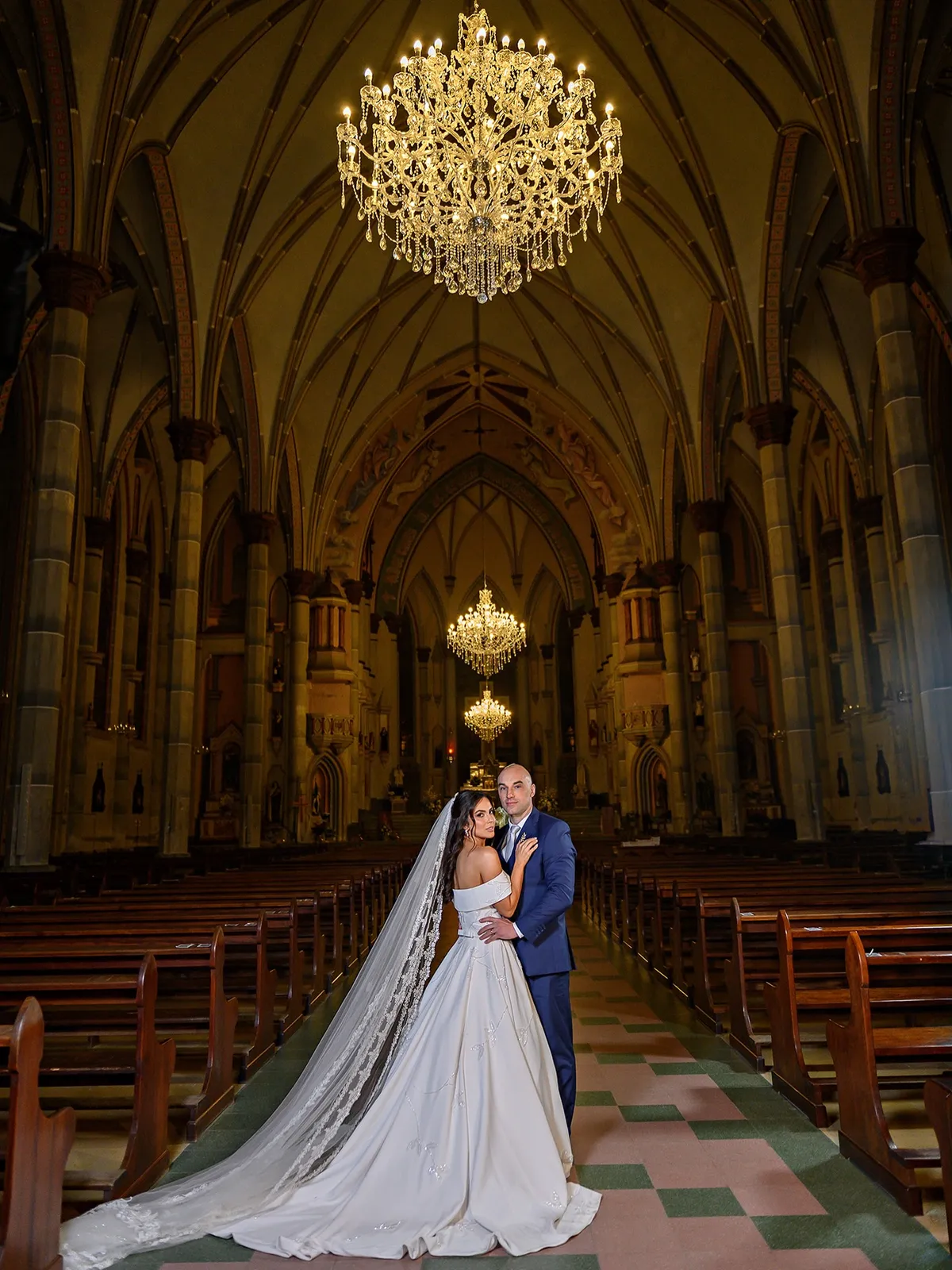 Noivos no altar de uma catedral com lustres